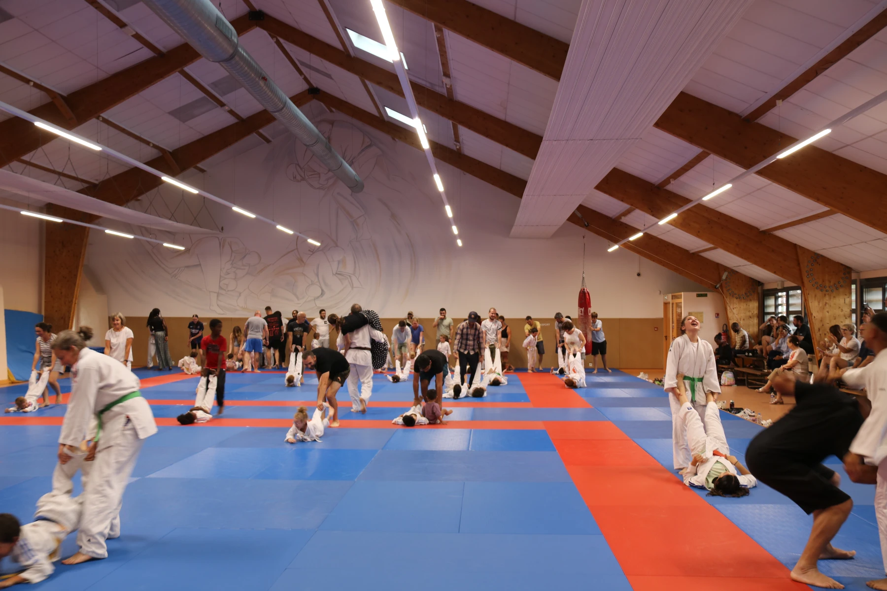 Le dojo rempli de familles qui s'amusent et pratiquent le judo ensemble lors du Dojo Family.