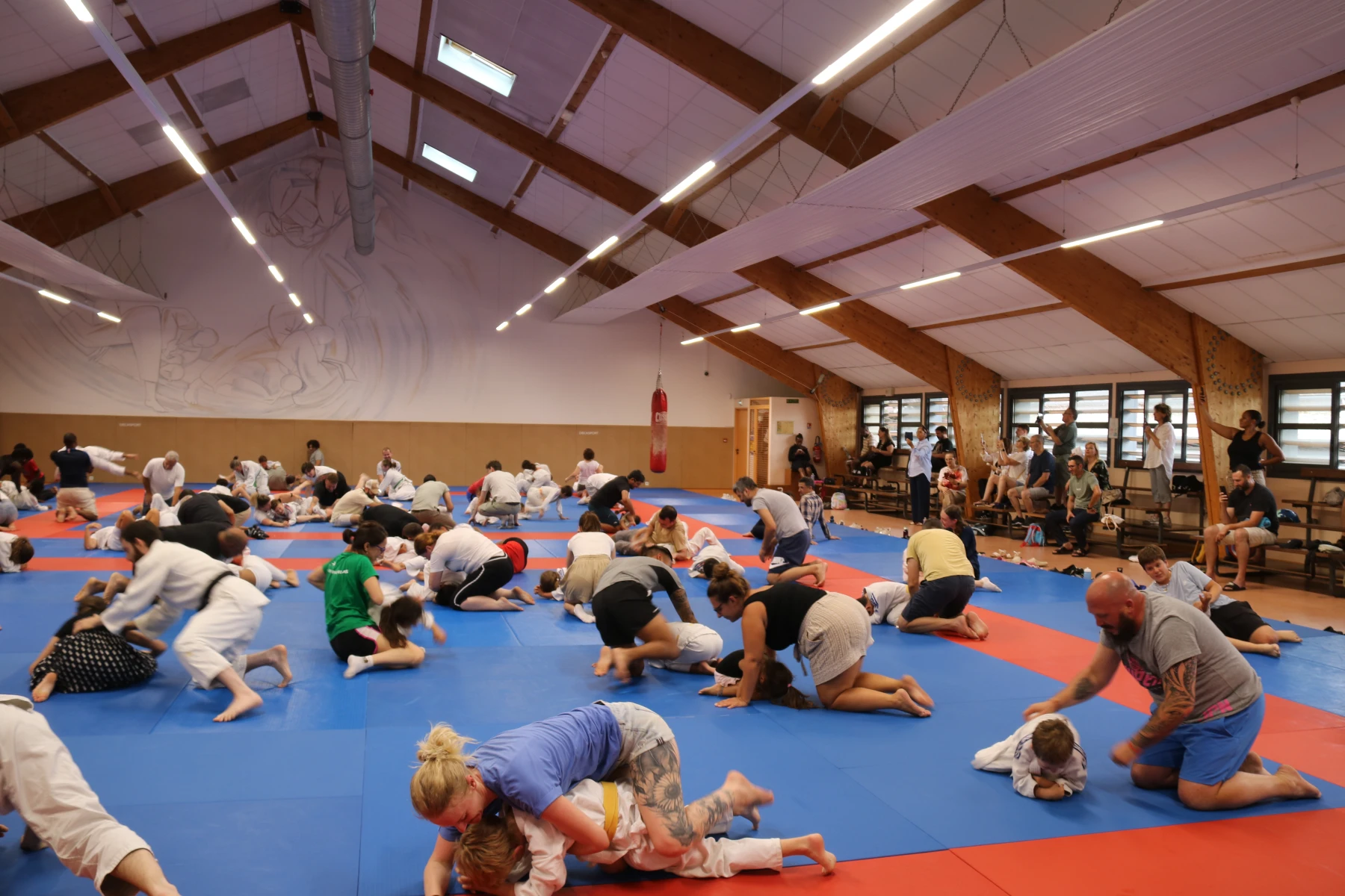 De nombreuses familles à genoux sur le tatami s'initient au travail au sol du judo.