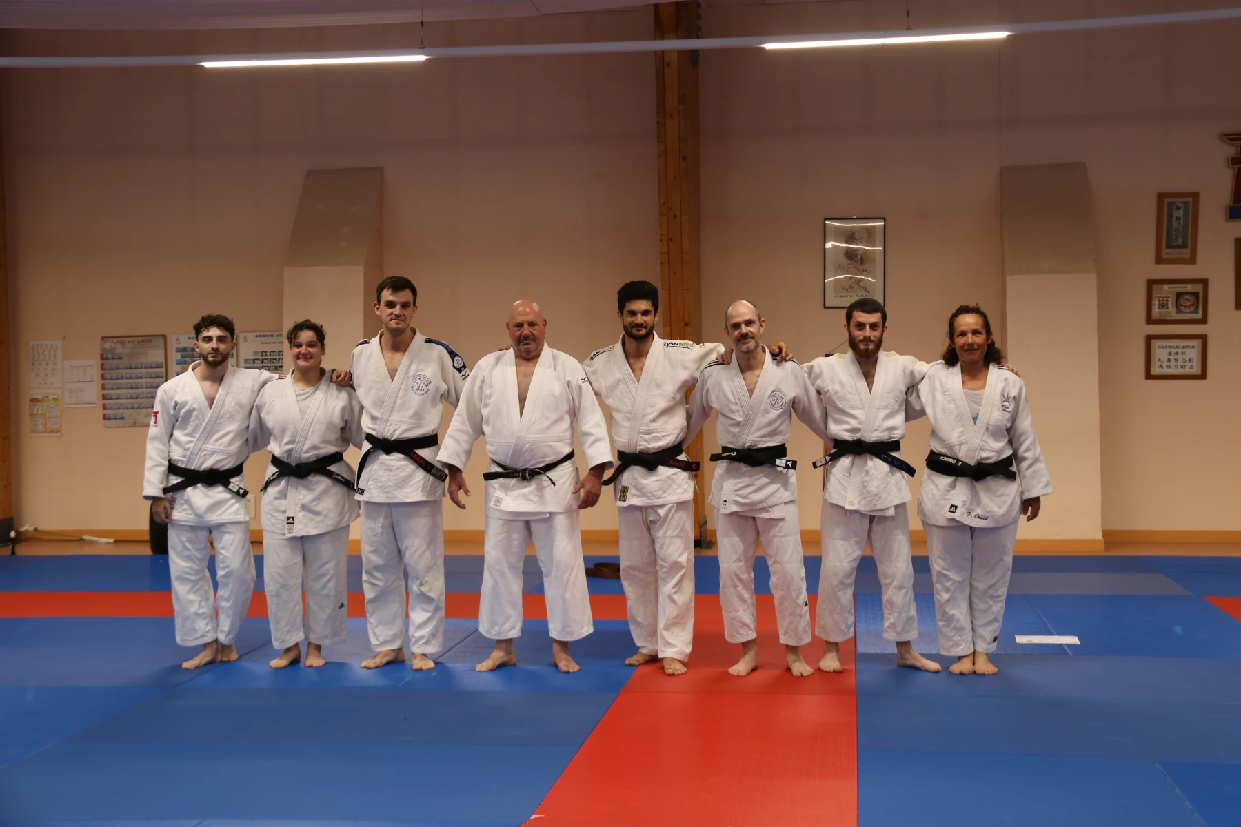 Photo de groupe des professeurs et assistants ceintures noires du club alignés sur le tatami.