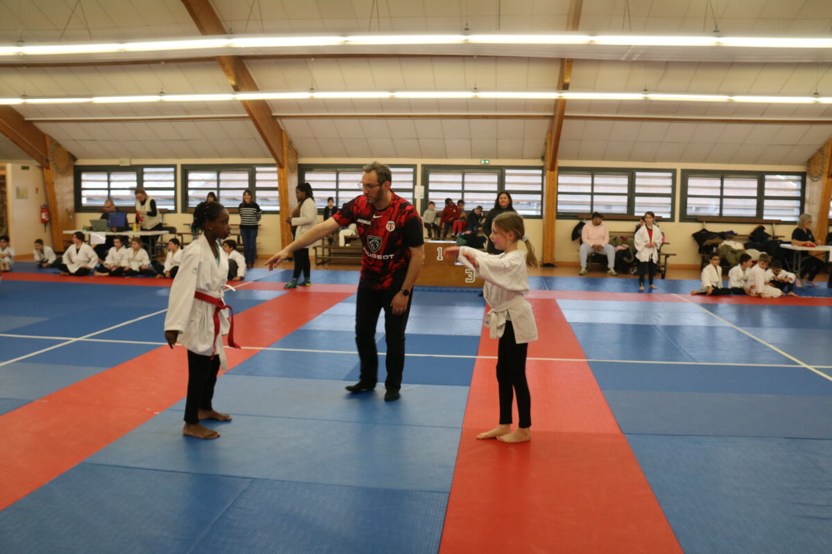 Grande photo de groupe du Dojo Family Day, avec des participants de tous âges et leurs familles, levant les mains en signe de célébration.