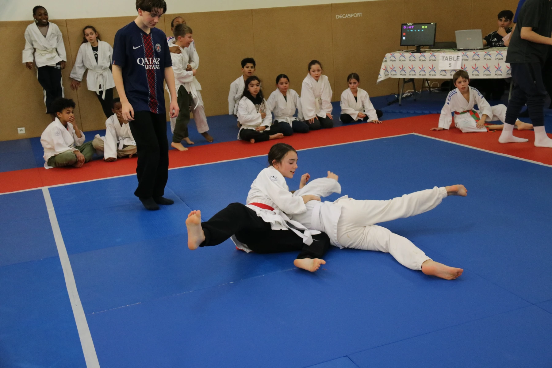 Un judoka projette son adversaire au sol lors d'un combat du tournoi des écoles.