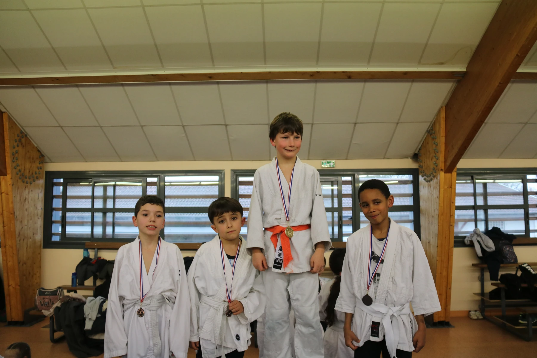 Groupe de jeunes judokas alignés avec leurs médailles après la remise des récompenses.